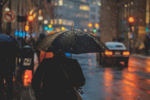 Man walking in rain with umbrella